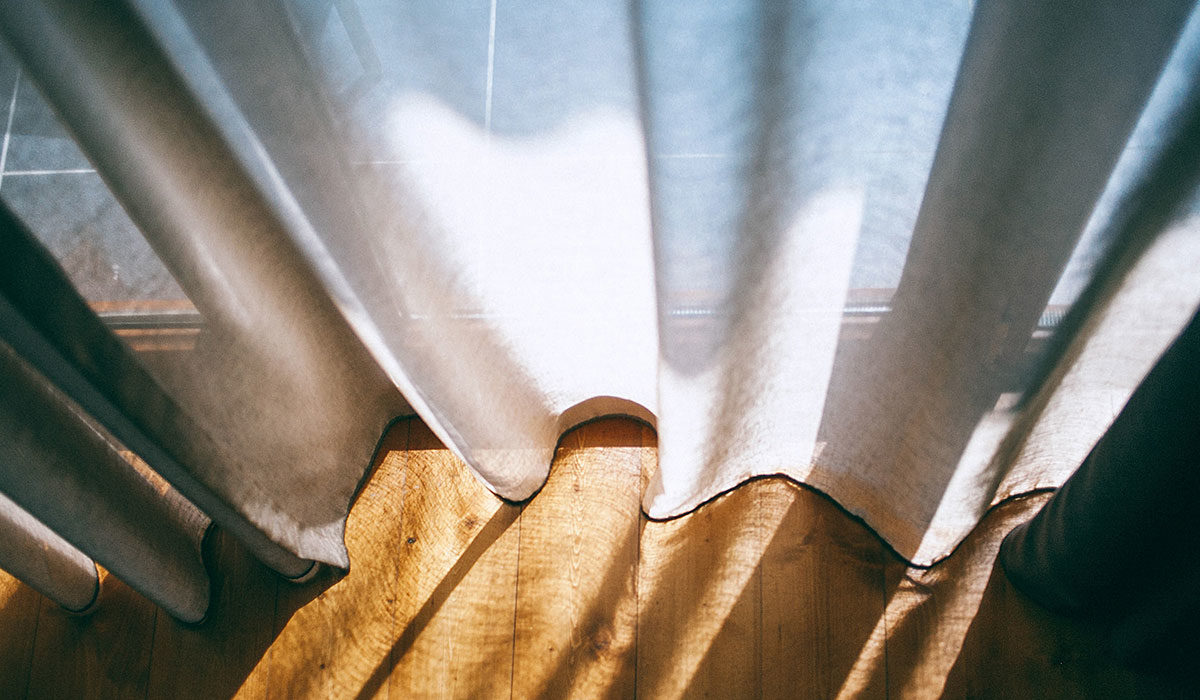 sun streaming through a white curtain