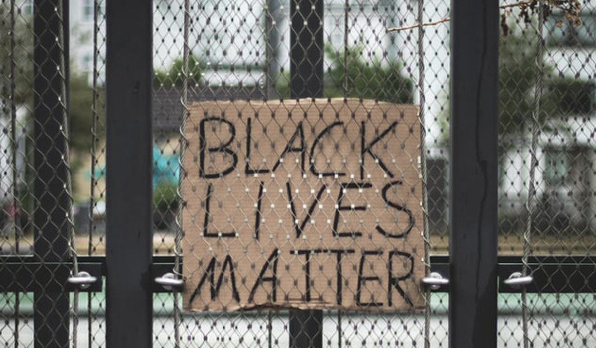 a black lives matter sign against a fence