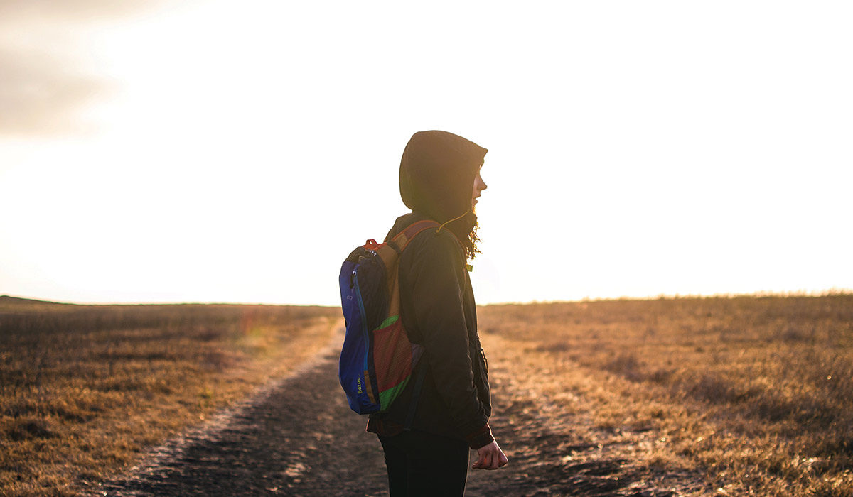 a person wearing a backpack standing on a trail