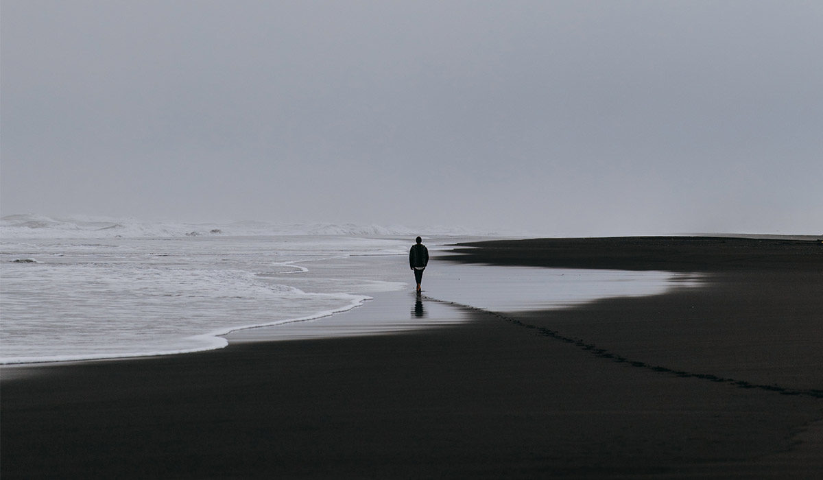 a person walking alone down a beach