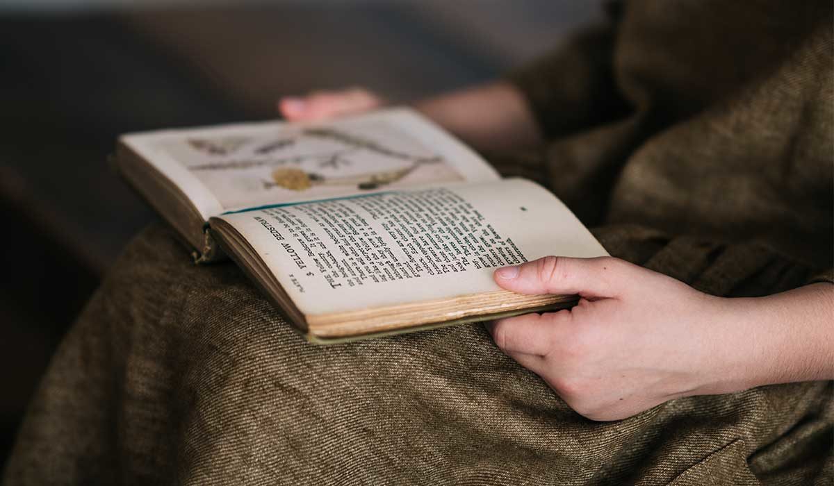 person sitting with a book open in their lap