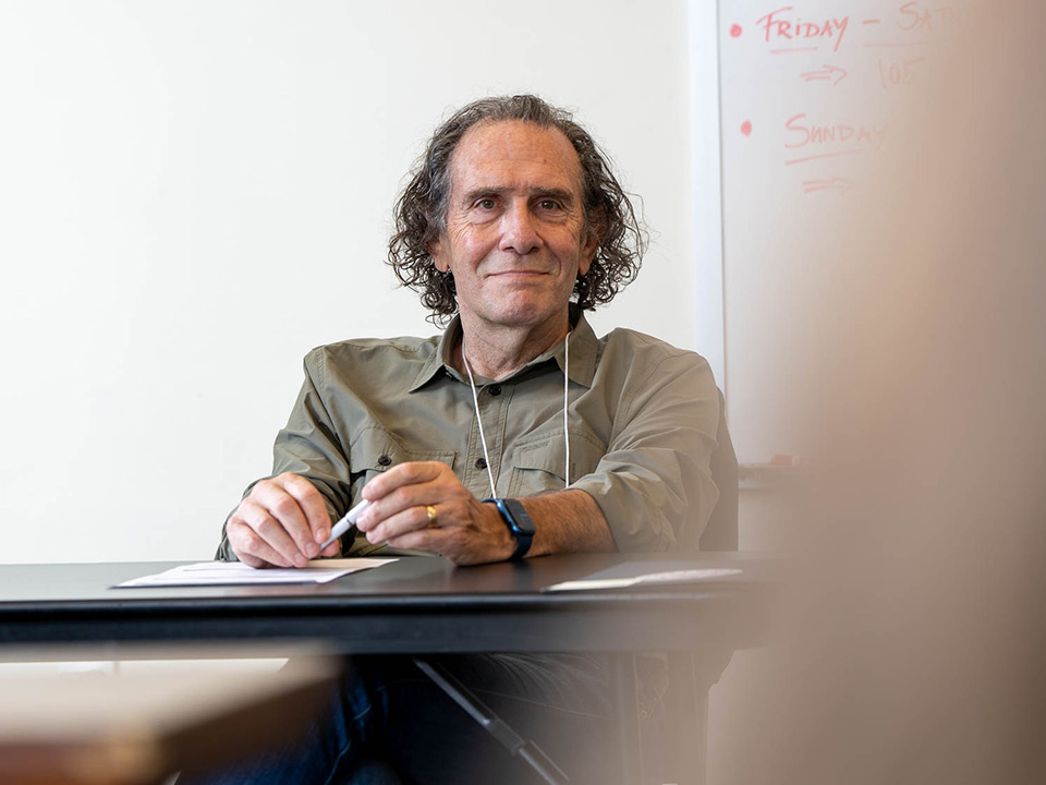 Dan Allender at a desk listening with a pen in hand